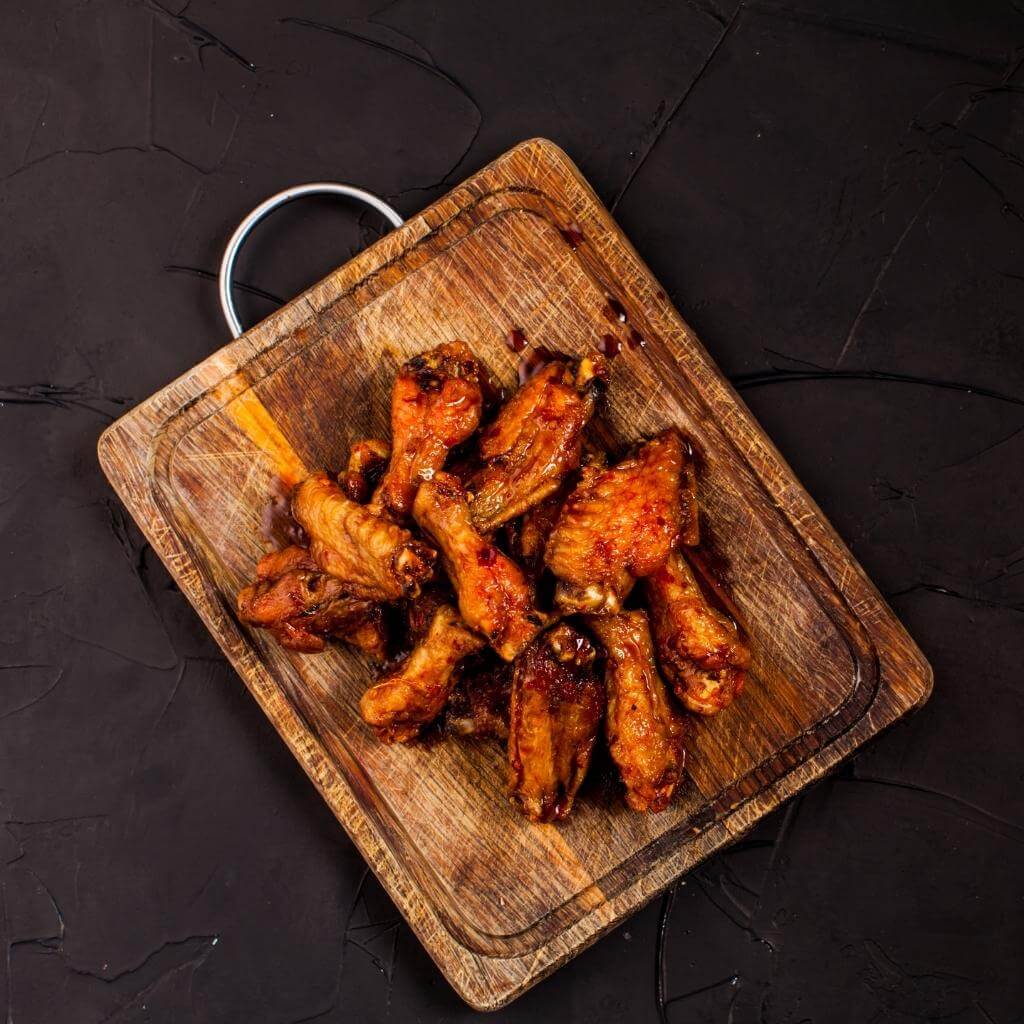 Plate of Honey-Glazed Irish Whiskey Chicken Wings with a side of dipping sauce.