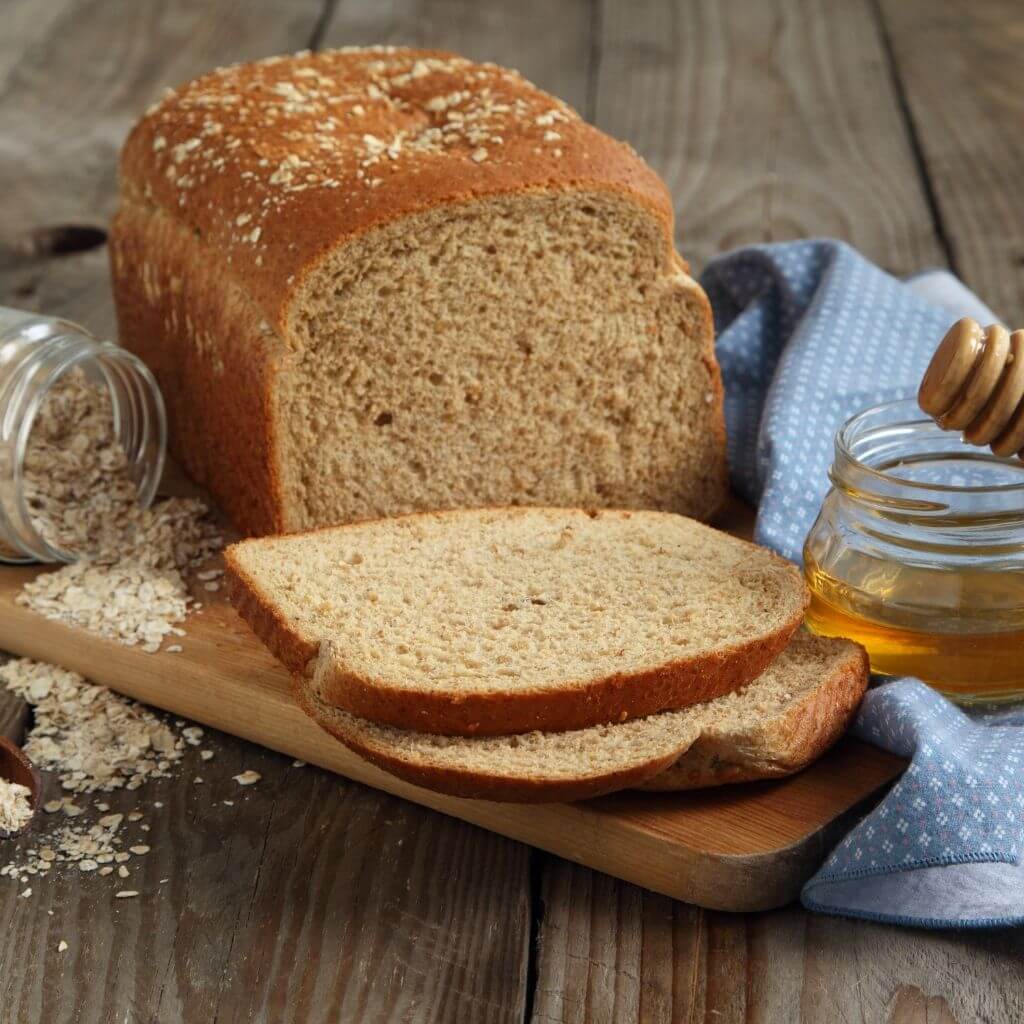 Freshly baked Honey Whole Wheat Bread, a golden-brown loaf with a honey-glazed crust.