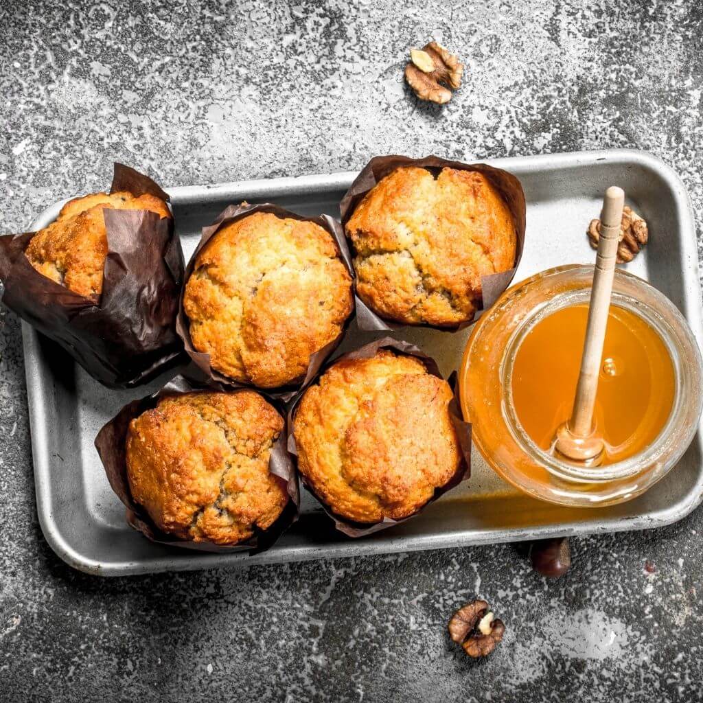 Honey and Walnut Muffins, a batch of moist muffins loaded with walnuts and drizzled with honey.