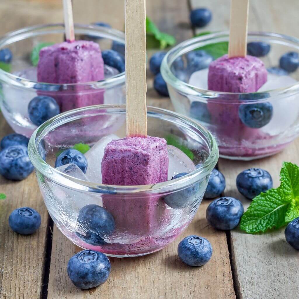 Honey and Yogurt Parfait Popsicles, a frozen treat with layers of yogurt, granola, and honey, on a stick.