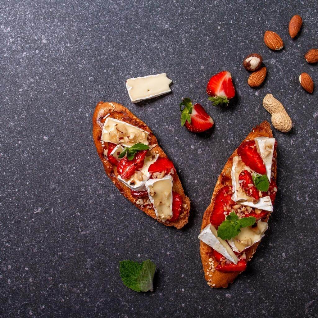 Honey and Goat Cheese Crostini on a serving platter garnished with fresh herbs.