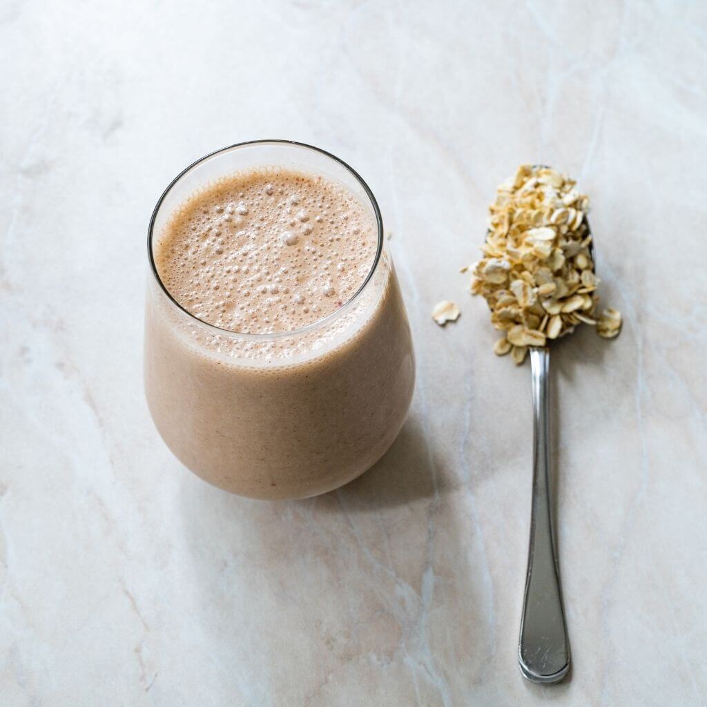 Glass of Honey and Oatmeal Smoothie, a creamy blend with oats, honey, and sliced bananas.